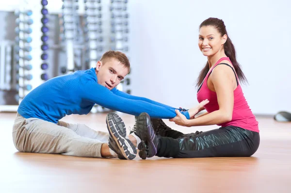 Uomo e donna in palestra facendo stretching — Foto Stock