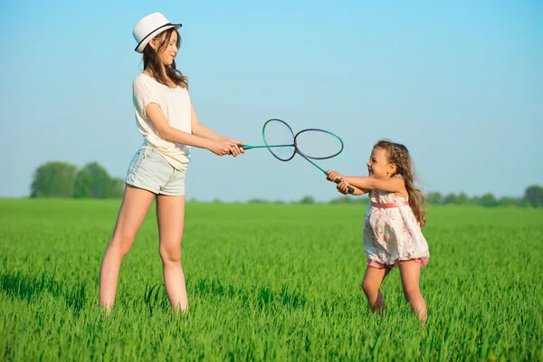 Flickor leker med ett racket i badminton — Stockfoto