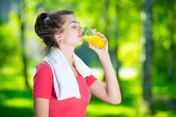 Mulher bebendo suco de laranja fresco — Fotografia de Stock