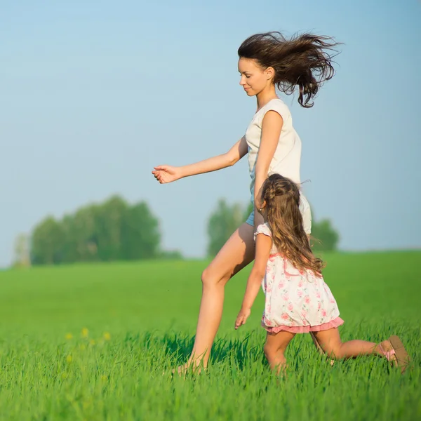 Girls running down green wheat field — Stock Photo, Image