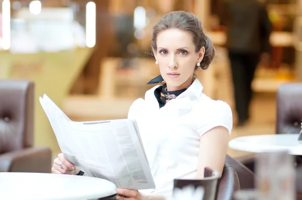 Serious business woman reading newspaper — Stock Photo, Image