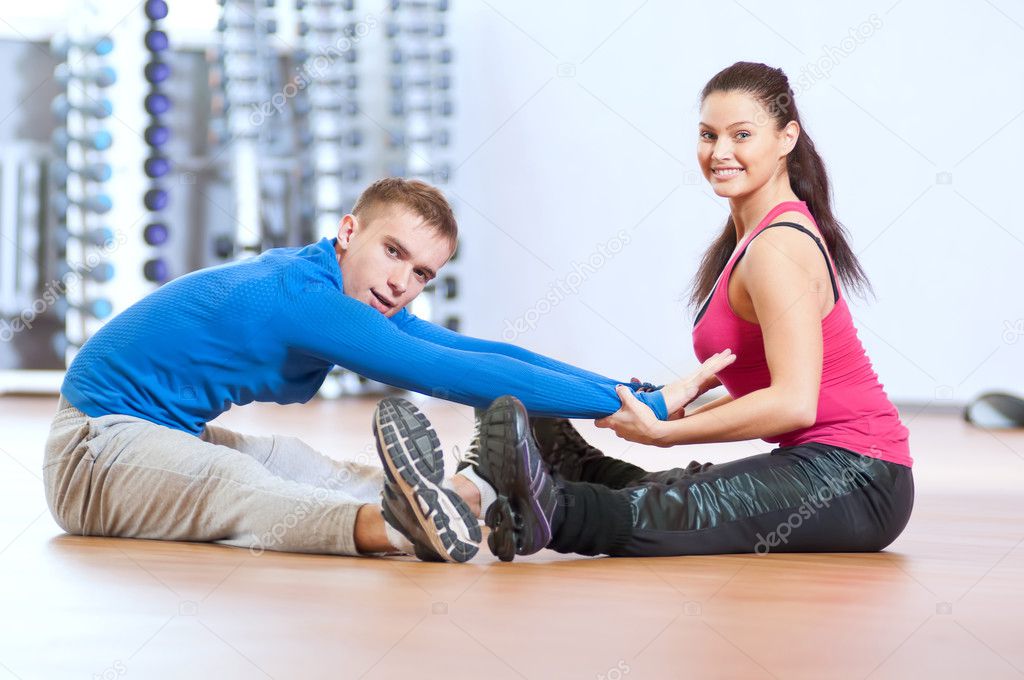 Man and woman at the gym doing stretching