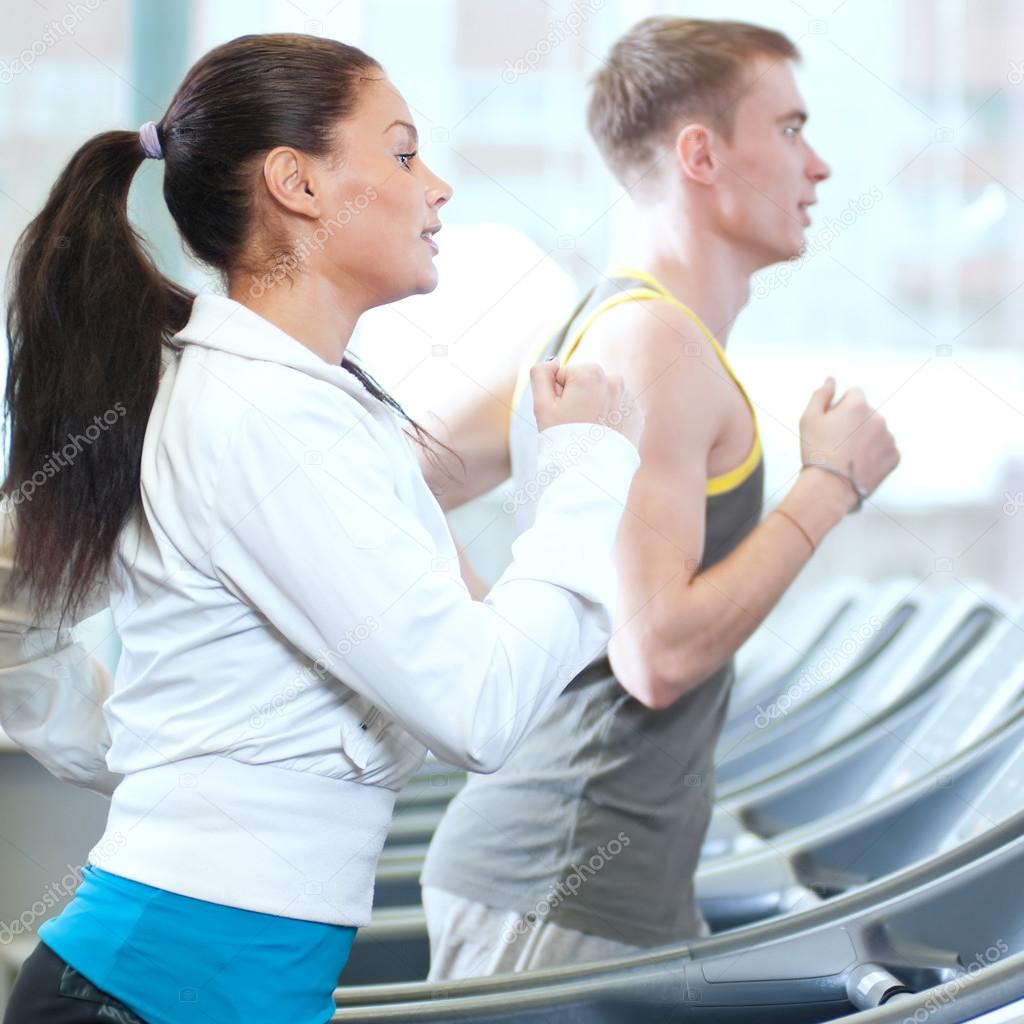 Woman and man at the gym exercising