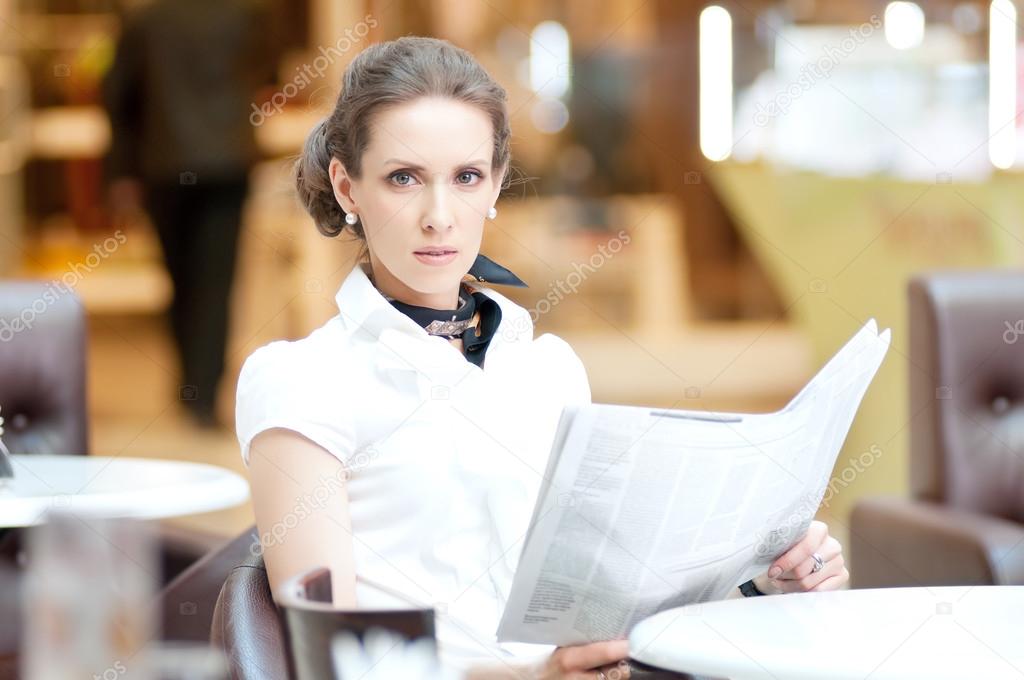Business woman reading newspaper