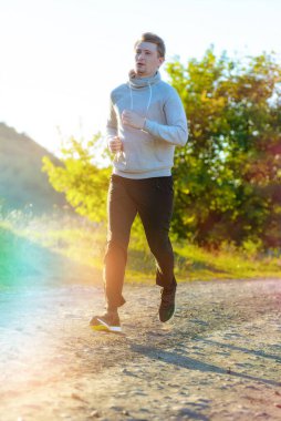 Güzel bir yaz gününde kırsal kesimde koşan bir adam. Spor fitness modeli Kafkasya etnik köken eğitimi.