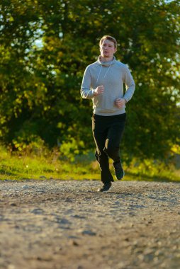 Güzel bir yaz gününde kırsal kesimde koşan bir adam. Spor fitness modeli Kafkasya etnik köken eğitimi.
