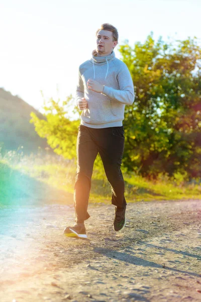 Man jogging in rural nature at beautiful summer day. Sport fitness model caucasian ethnicity training outdoor. — Stock Photo, Image