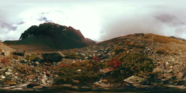 360 Vr a hegyi völgy időeltolódása ősszel. Vad végtelen természet és hóvihar felhők. A nap sugarai zöld fű és sziklák felett. — Stock videók