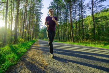 Adam güzel bir yaz gününde şehir parkında koşuyor. Spor fitness modeli Kafkasya etnik köken eğitimi.