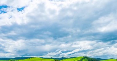 Yaz ya da sonbahar mevsiminde dağdaki çayır zaman atlaması. Vahşi doğa ve kırsal alan. Hızlı bulutlar, yeşil çimenler ve güneş ışınları.