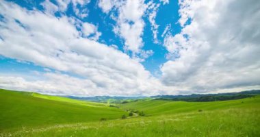 Yaz ya da sonbahar mevsiminde dağdaki çayır zaman atlaması. Vahşi doğa ve kırsal alan. Hızlı bulutlar, yeşil çimenler ve güneş ışınları.