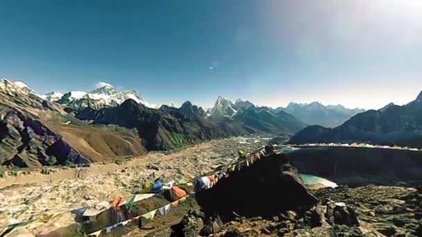 구카요 라이산 정상. 티베트의 불교 깃발. 야생 히말라야는 높은 고도의 자연과 산의 계곡입니다. 바위가 많은 산비탈에 얼음이 덮여 있다. 파노라마의 움직임 360 도 — 비디오