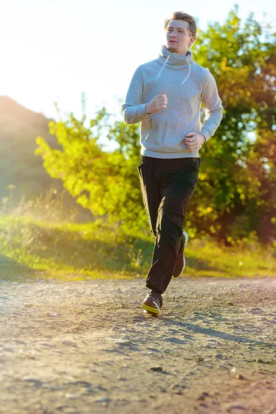 Man jogging in rural nature at beautiful summer day. Sport fitness model caucasian ethnicity training outdoor. — Stock Photo, Image