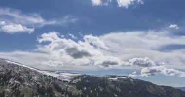 Dağların arkasındaki bulutların zaman çizelgesi. Kar, kayalar, uçurumlar ve derin mavi gökyüzü. Yüksek irtifa.