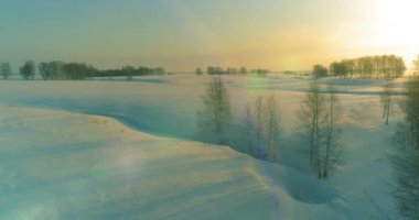 Soğuk arktik alan manzarası, karlı ağaçlar, buz nehri ve ufukta güneş ışınları. Aşırı düşük sıcaklık havası.