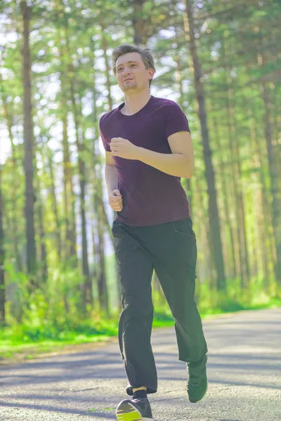 Man jogging in city partk at beautiful summer day. Sport fitness model caucasian ethnicity training outdoor. — Stock Photo, Image