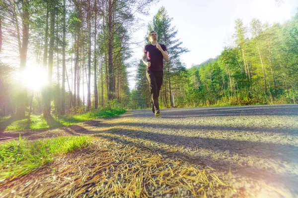 Hombre corriendo en la ciudad partk en hermoso día de verano. Deporte fitness modelo caucásico etnia entrenamiento al aire libre. — Foto de Stock