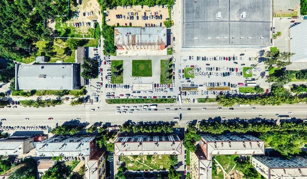 Vista aerea sulla città con crocevia e strade, case, edifici, parchi e parcheggi. Estate soleggiata immagine panoramica — Foto Stock