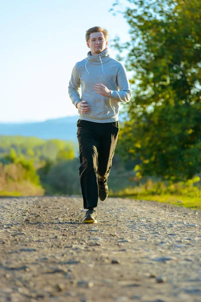 Człowiek jogging w wiejskiej przyrody w piękny letni dzień. Sport fitness model kaukaski etniczność trening outdoor. — Zdjęcie stockowe