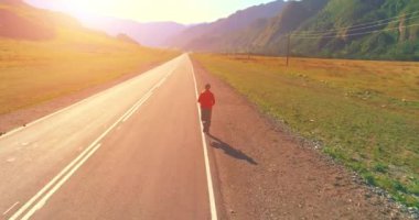 Mükemmel asfalt yolda sporcunun önünde alçak irtifa uçuşu.