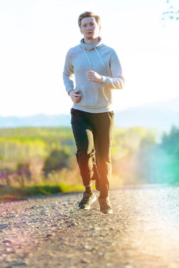 Güzel bir yaz gününde kırsal kesimde koşan bir adam. Spor fitness modeli Kafkasya etnik köken eğitimi.