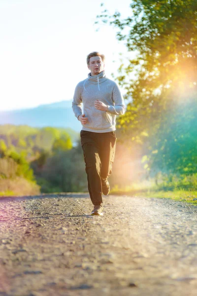 Man joggen in de landelijke natuur op mooie zomerdag. Sport fitness model Kaukasische etniciteit training outdoor. — Stockfoto