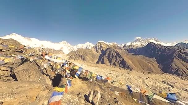 Le sommet de la montagne Gokyo Ri. Prière tibétaine drapeau bouddhiste. Himalaya sauvage haute altitude nature et vallée de montagne. Pentes rocheuses couvertes de glace. Mouvement panoramique 180 degrés — Video