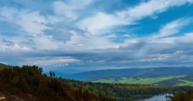 Dağ Gölü yaz ya da sonbahar zamanında zaman atlaması. Vahşi doğa ve kırsal alan. Bulutların hareketi, yeşil çimenler ve dramatik gökyüzü. Motorlu doli kaydırıcı
