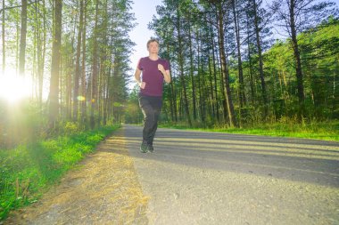 Adam güzel bir yaz gününde şehir parkında koşuyor. Spor fitness modeli Kafkasya etnik köken eğitimi.