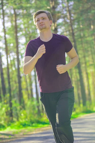 Hombre corriendo en la ciudad partk en hermoso día de verano. Deporte fitness modelo caucásico etnia entrenamiento al aire libre. —  Fotos de Stock