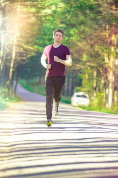 Man jogging in city partk at beautiful summer day. Sport fitness model caucasian ethnicity training outdoor. — Stock Photo, Image