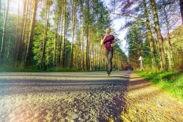 Man jogging in city partk at beautiful summer day. Sport fitness model caucasian ethnicity training outdoor. — Stock Photo, Image