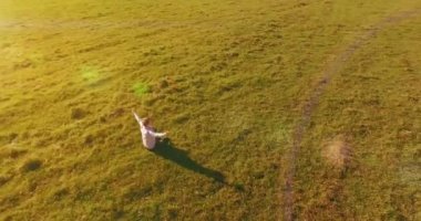 Yeşil çimlerin üzerinde sarı kırsal alanda not defteri olan bir adamın etrafında alçak yörünge uçuşları..