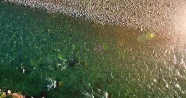 Güneşli yaz sabahında kayalarla birlikte taze, hızlı dağ nehri üzerinde alçak irtifa uçuşu..