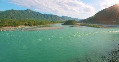 Güneşli yaz sabahında kayalarla birlikte taze, hızlı dağ nehri üzerinde alçak irtifa uçuşu..