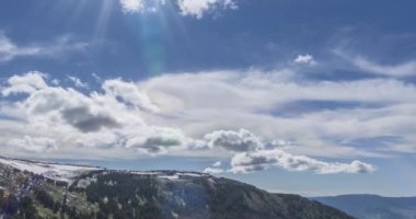 Dağların arkasındaki bulutların zaman çizelgesi. Kar, kayalar, uçurumlar ve derin mavi gökyüzü. Yüksek irtifa.