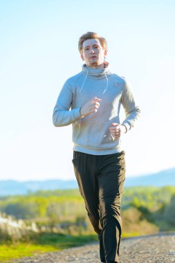 Güzel bir yaz gününde kırsal kesimde koşan bir adam. Spor fitness modeli Kafkasya etnik köken eğitimi.