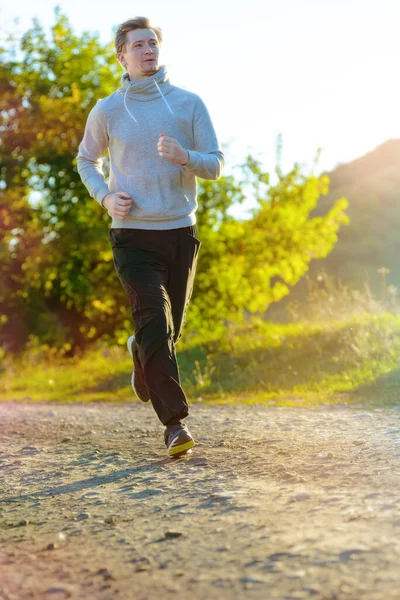 Man joggen in de landelijke natuur op mooie zomerdag. Sport fitness model Kaukasische etniciteit training outdoor. — Stockfoto