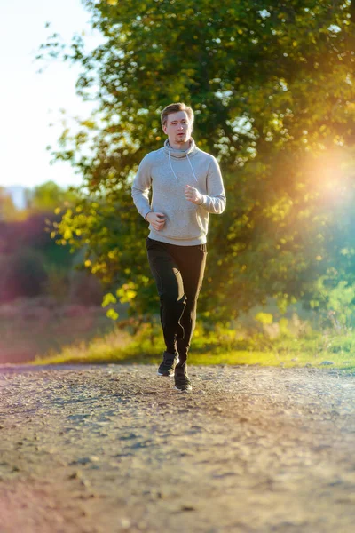 Man jogging in rural nature at beautiful summer day. Sport fitness model caucasian ethnicity training outdoor. — Stock Photo, Image