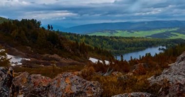 Dağ Gölü yaz ya da sonbahar zamanında zaman atlaması. Vahşi doğa ve kırsal alan. Bulutların hareketi, yeşil çimenler ve dramatik gökyüzü. Motorlu doli kaydırıcı