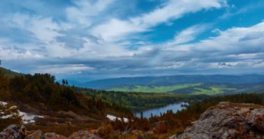 Dağ Gölü yaz ya da sonbahar zamanında zaman atlaması. Vahşi doğa ve kırsal alan. Bulutların hareketi, yeşil çimenler ve dramatik gökyüzü. Motorlu doli kaydırıcı
