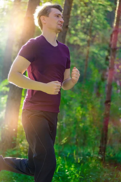 Чоловік біжить у парку міста в прекрасний літній день. Спортивна фітнес-модель кавказької етнічної підготовки на відкритому повітрі . — стокове фото