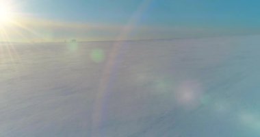 Soğuk kış manzarası kutup bölgesi, karla kaplı ağaçlar, ufukta buz nehri ve güneş ışınları. Aşırı düşük sıcaklık havası.