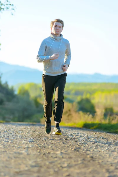 Man jogging in rural nature at beautiful summer day. Sport fitness model caucasian ethnicity training outdoor. — Stock Photo, Image