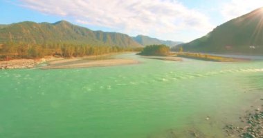 Güneşli yaz sabahında kayalarla birlikte taze, hızlı dağ nehri üzerinde alçak irtifa uçuşu..