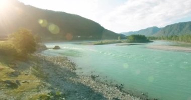 Güneşli yaz sabahında kayalarla birlikte taze, hızlı dağ nehri üzerinde alçak irtifa uçuşu..