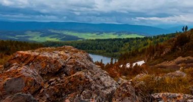 Dağ Gölü yaz ya da sonbahar zamanında zaman atlaması. Vahşi doğa ve kırsal alan. Bulutların hareketi, yeşil çimenler ve dramatik gökyüzü. Motorlu doli kaydırıcı