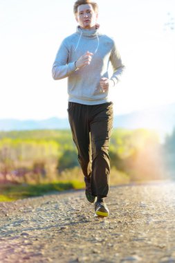 Güzel bir yaz gününde kırsal kesimde koşan bir adam. Spor fitness modeli Kafkasya etnik köken eğitimi.