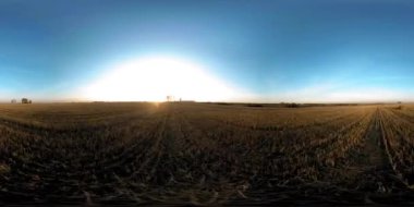 360 hava manzaralı. Güneşli bir sonbahar akşamında sonsuz yeşil tarlaları olan yaz manzarasının üzerinde alçak uçuş. Ufuktaki güneş ışınları. Hızlı yatay hareket. Sabitlendi ve yamandı.