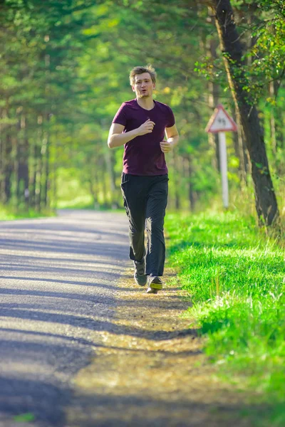 Man jogging in city partk at beautiful summer day. Sport fitness model caucasian ethnicity training outdoor. — Stock Photo, Image